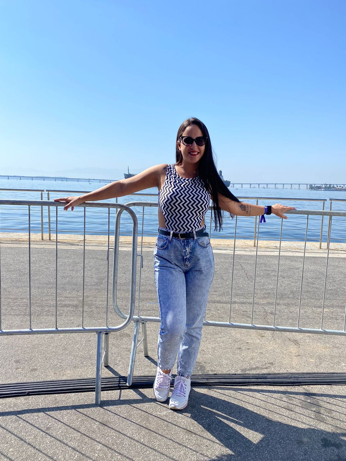 Imagem de nathalia vestindo roupa rosa e sorrindo com o mar no fundo